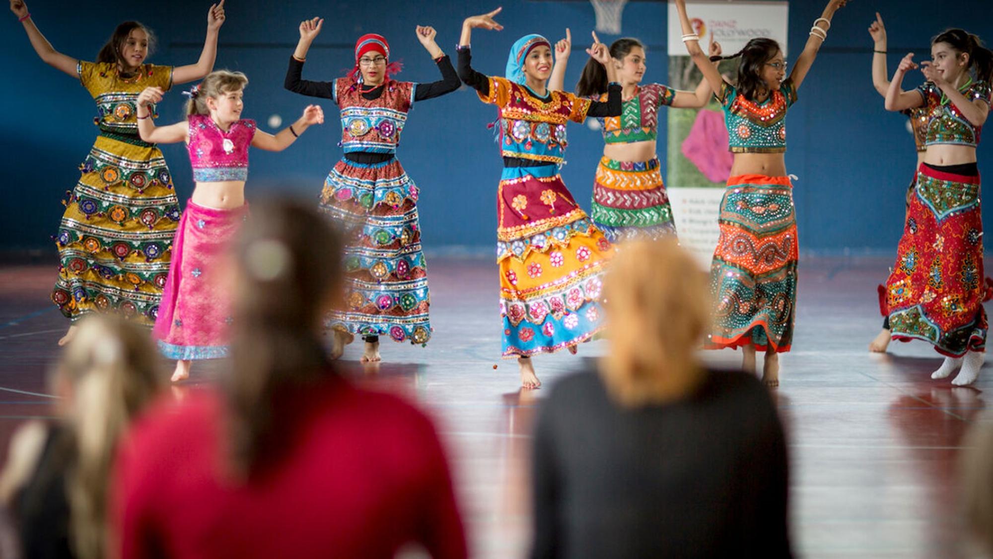 Eine Tanzgruppe bestehend aus Jugendlichen in farbenfrohen Röcken